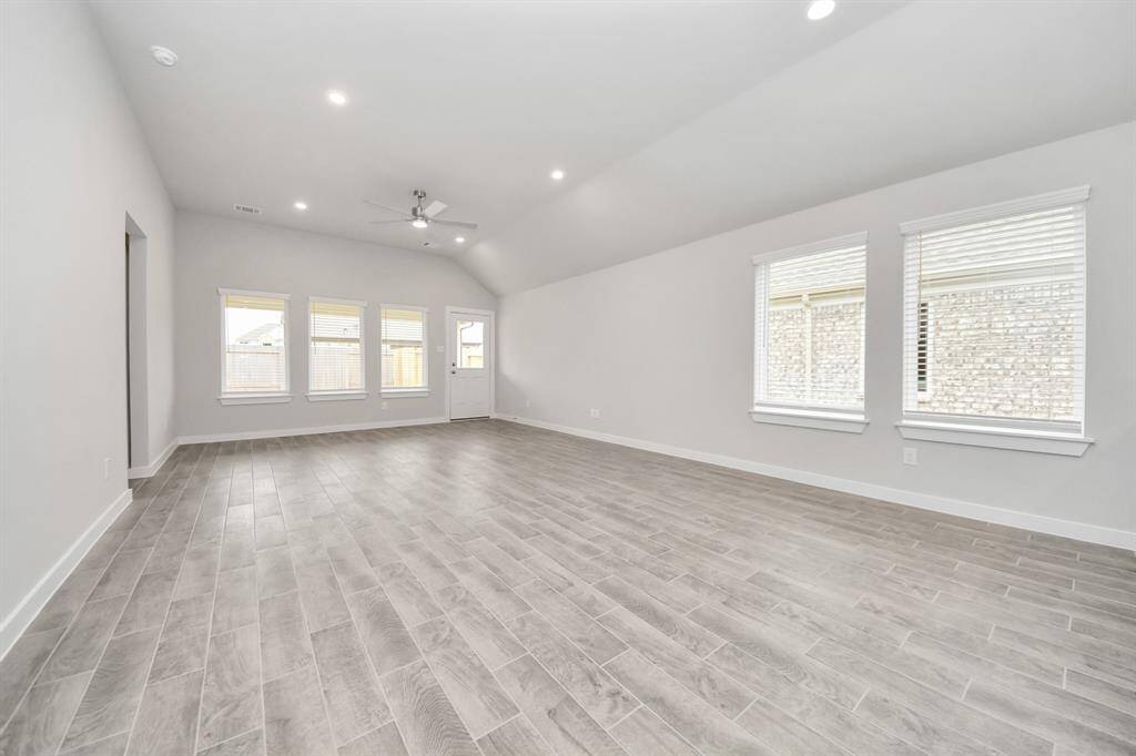Gather the family and guests together in your lovely living room! Featuring soaring highceilings, recessed lighting, ceiling fan, custom paint, gorgeous floors, and large windows thatprovide plenty of natural lighting throughout the day. Sample photo of completed home with similar floor plan. Actual colors and selections may vary.