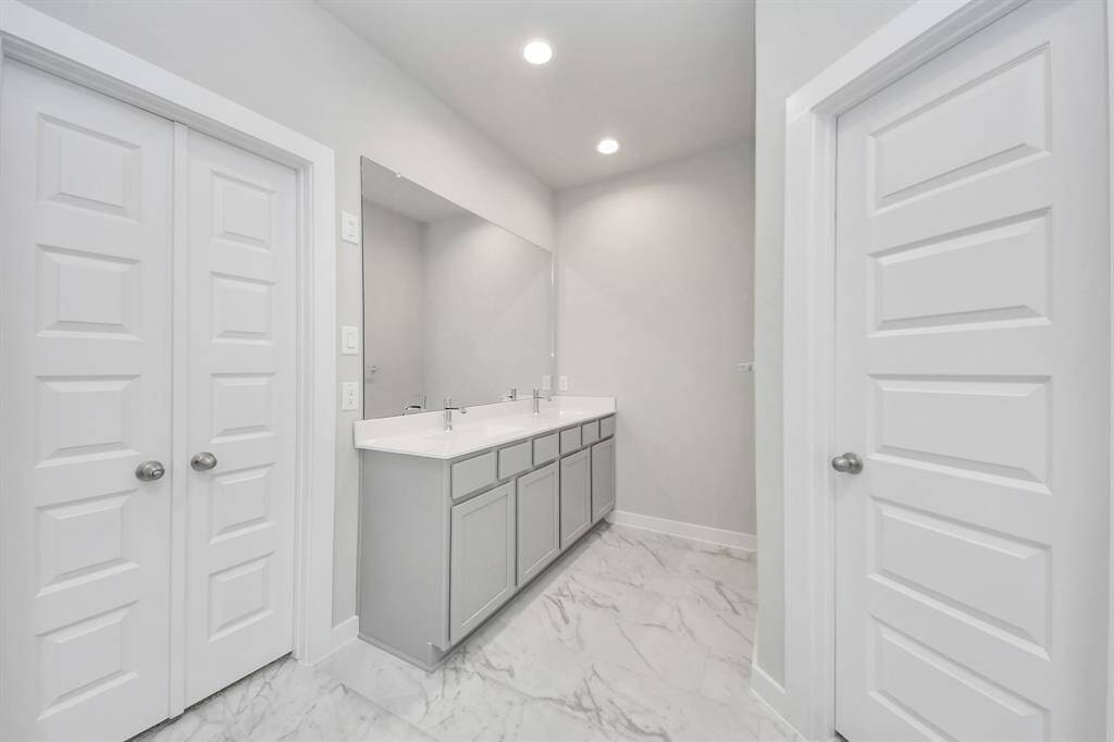 Elevate your dailyroutine at the elegant vanity, now equipped with double sinks, lightcountertops, modern hardware, and beautiful recessed lights. Sample photo of completed home with similar floor plan. Actual colors and selections may vary.