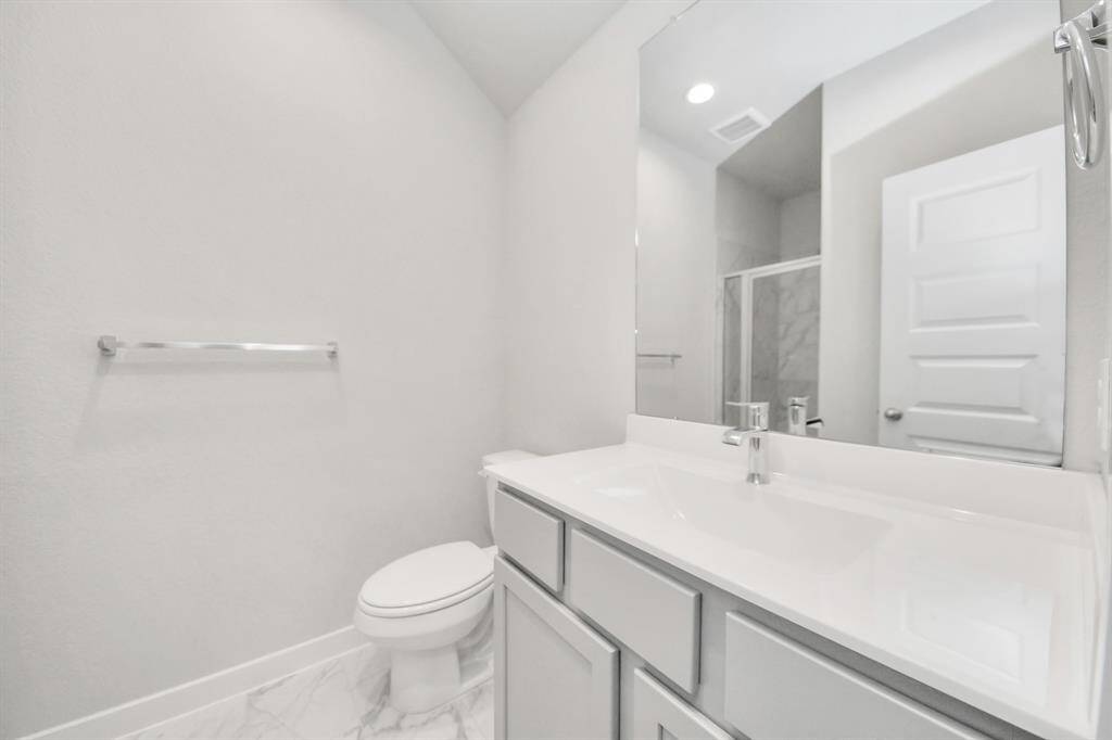 Experience sophistication in the guest suite bathroom, where tile flooringcomplements a walk-in shower with tile surround. Light wood cabinets completewith a beautiful light countertop, enhances the space for a truly invitingambiance. Sample photo of completed home with similar floor plan. Actual colors and selections may vary.