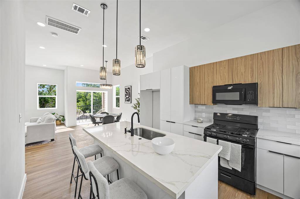 Sleek kitchen featuring modern cabinets, stunning quartzite countertops, and a built-in soap and disposal button all designed for a clean, seamless look and ultimate convenience.