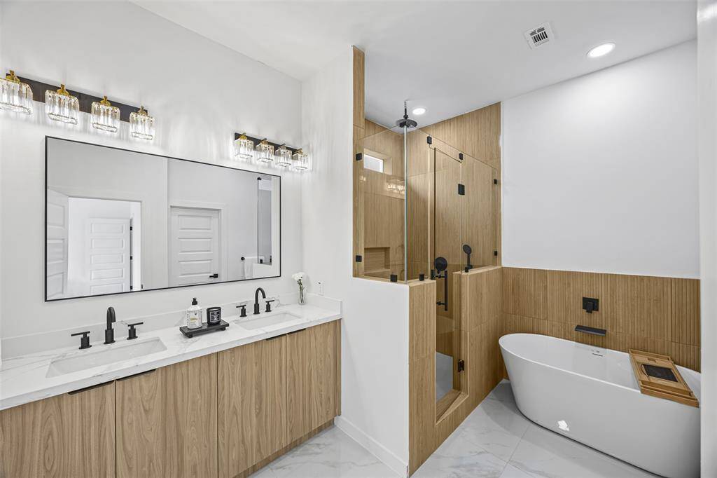 Step into your personal spa with this tranquil primary bathroom  featuring a luxurious standalone tub, rainfall showerhead, and serene finishes designed for ultimate relaxation.