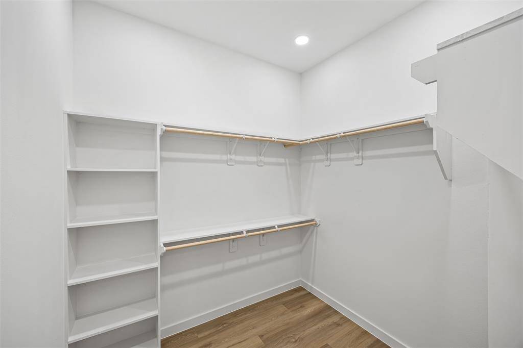 Spacious walk-in closet featuring custom built-in shelving, offering plenty of room and organization for all your essentials.