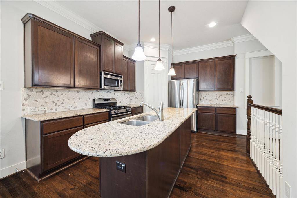Open kitchen with an island and stainless steel appliances.