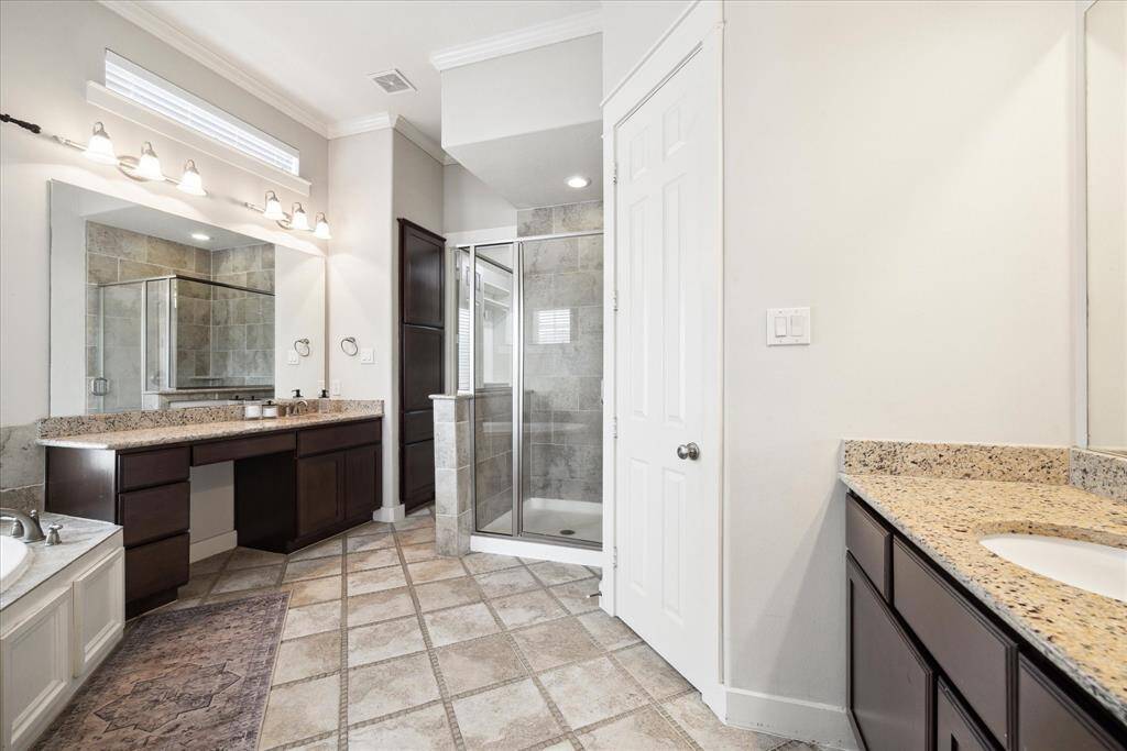 The primary bathroom features dual sinks, vanity area, separate shower and soaking spa tub.