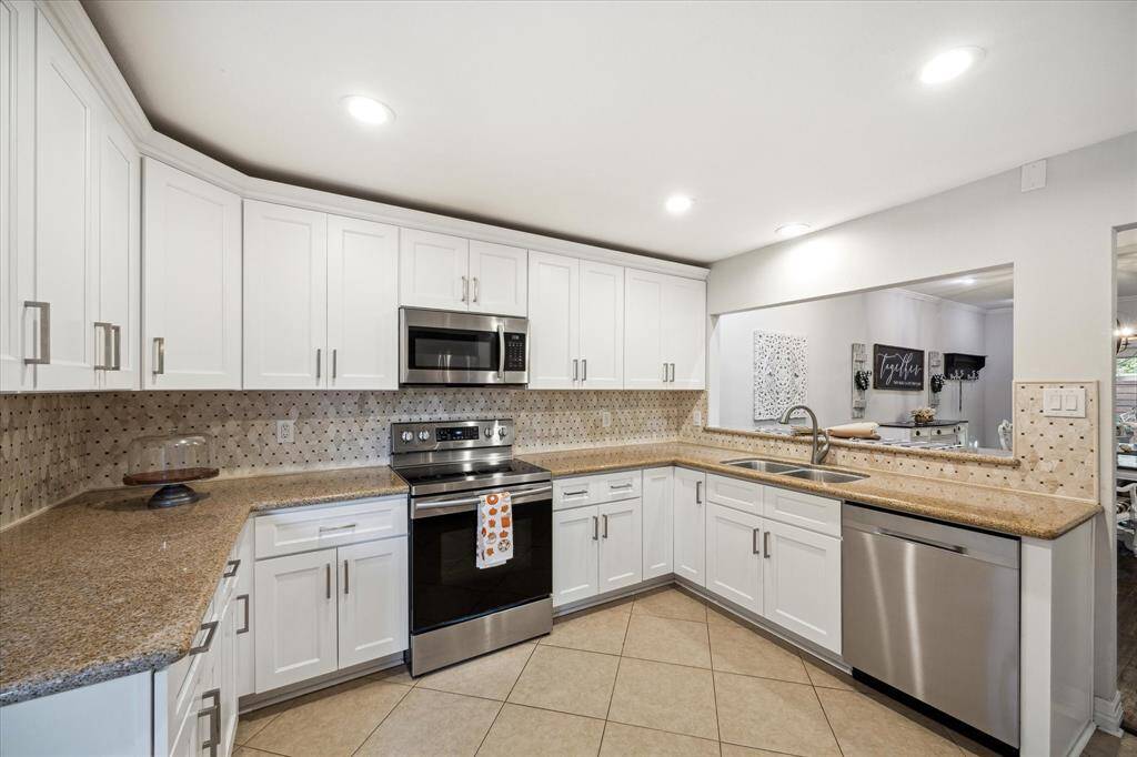 The kitchen features stainless steel appliances and plenty of storage and counter space.