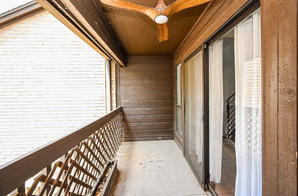 This inviting balcony features a sleek ceiling fan and sliding glass doors, perfect for relaxing and enjoying the fresh air.