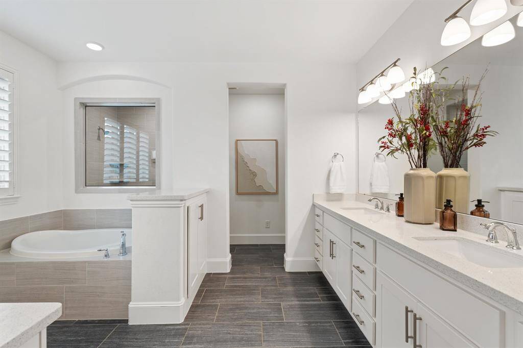 The spa like bathroom features double sinks, a separate tub, walk-in shower, and dedicated vanity area.