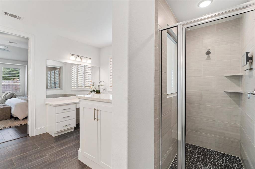 A view of the primary walk-in shower, tucked away at the back of the bathroom, offering plenty of privacy.