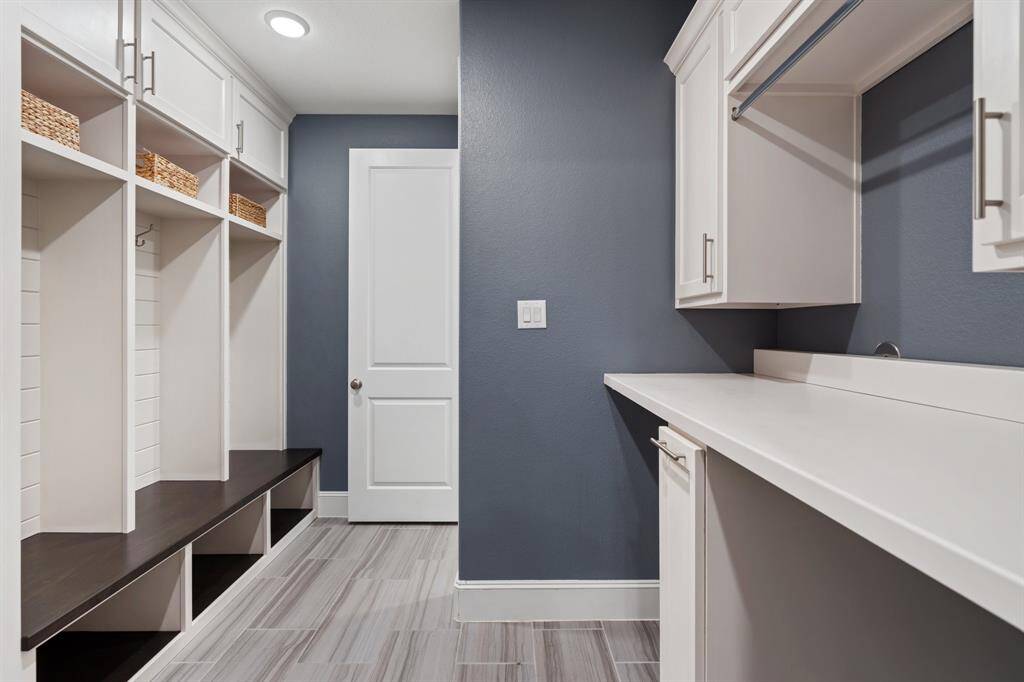 This expertly laid out mud/laundry room is conveniently located between the primary closet and the garage. Offering easy access from the primary suite to the utility room and the perfect drop space when entering from the garage, with built in lockers and ample storage.