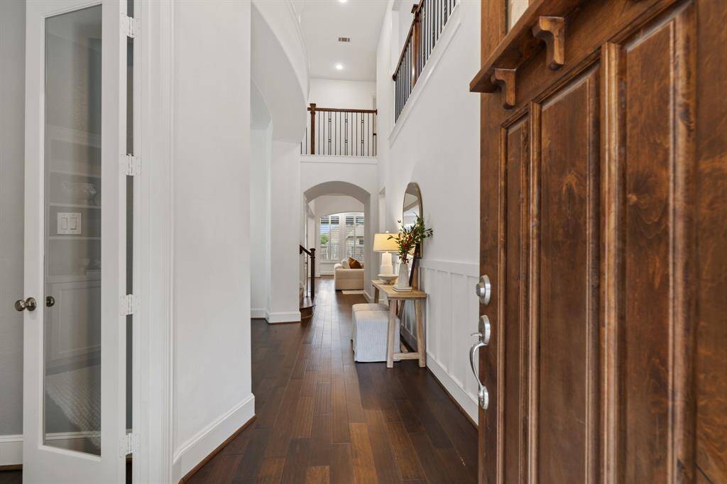 Enter through the grand entry with two story ceiling heights and wainscoting accents. French glass doors to your left lead to the home office.