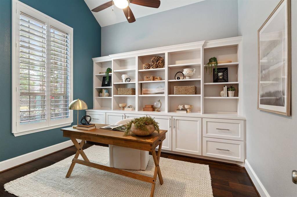 The well-appointed dedicated home office at the front of the home features custom built in cabinetry.