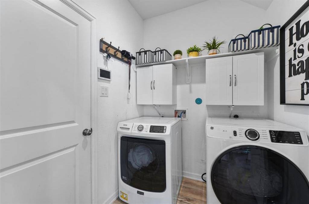 Convenient laundry room with built-in storage and space for organization right off the main living areas.