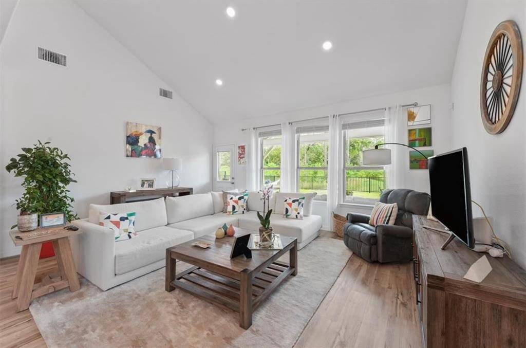 Step into a bright, open-concept living space with soaring ceilings, large windows, and luxury flooring throughout.