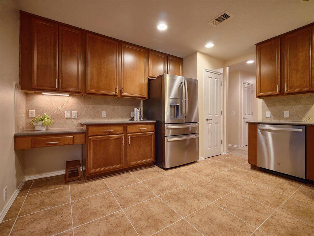 Lovely walnut colored cabinetry in the ample kitchen.