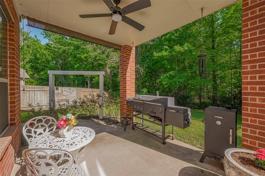 Downstairs covered patio leads out to a sprawling, fenced backyard.