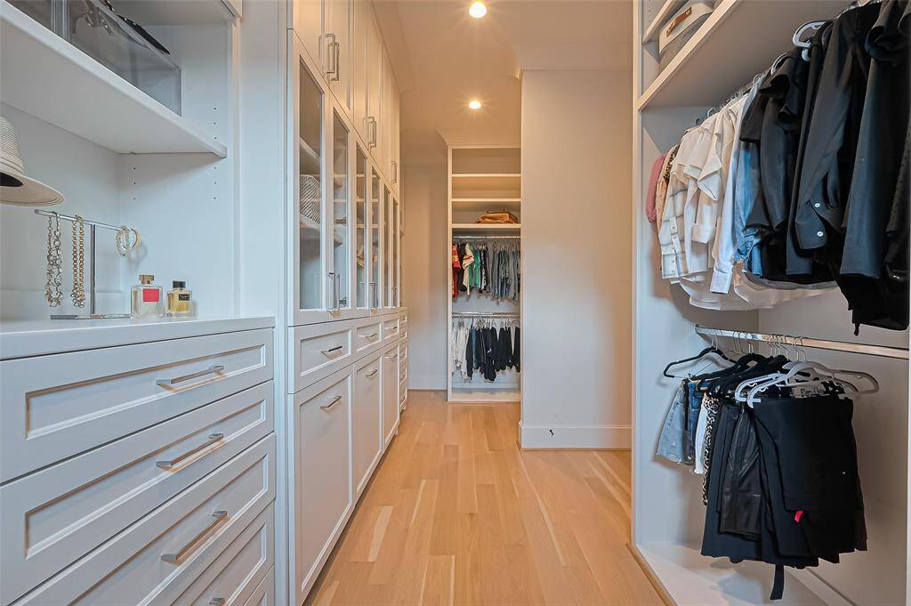 The primary bedroom's walk-in closet provides ample space for all your shoes and clothing, featuring built-in shelves and drawers for enhanced organization.