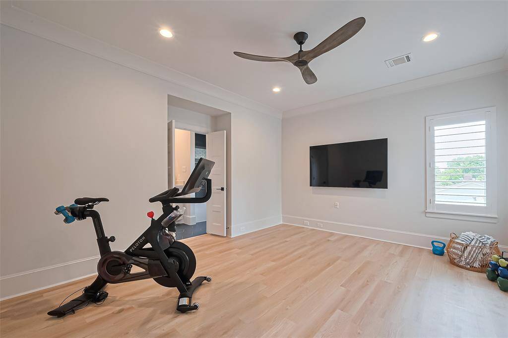 The third bedroom, located upstairs, is currently utilized as a workout room. It features a walk-in closet and an ensuite bathroom. A 55-inch television screen is also available for purchase.