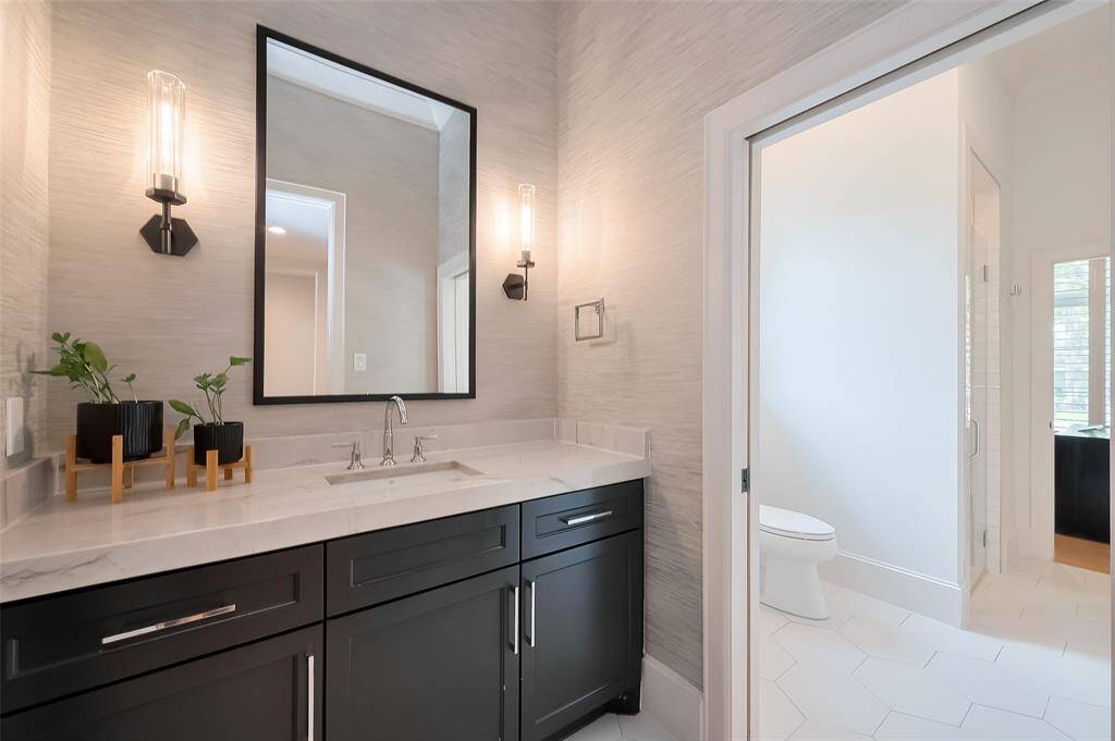 This full bathroom is conveniently located downstairs, accessible from both the office/secondary bedroom and the formal living room. Solid Surface countertops.