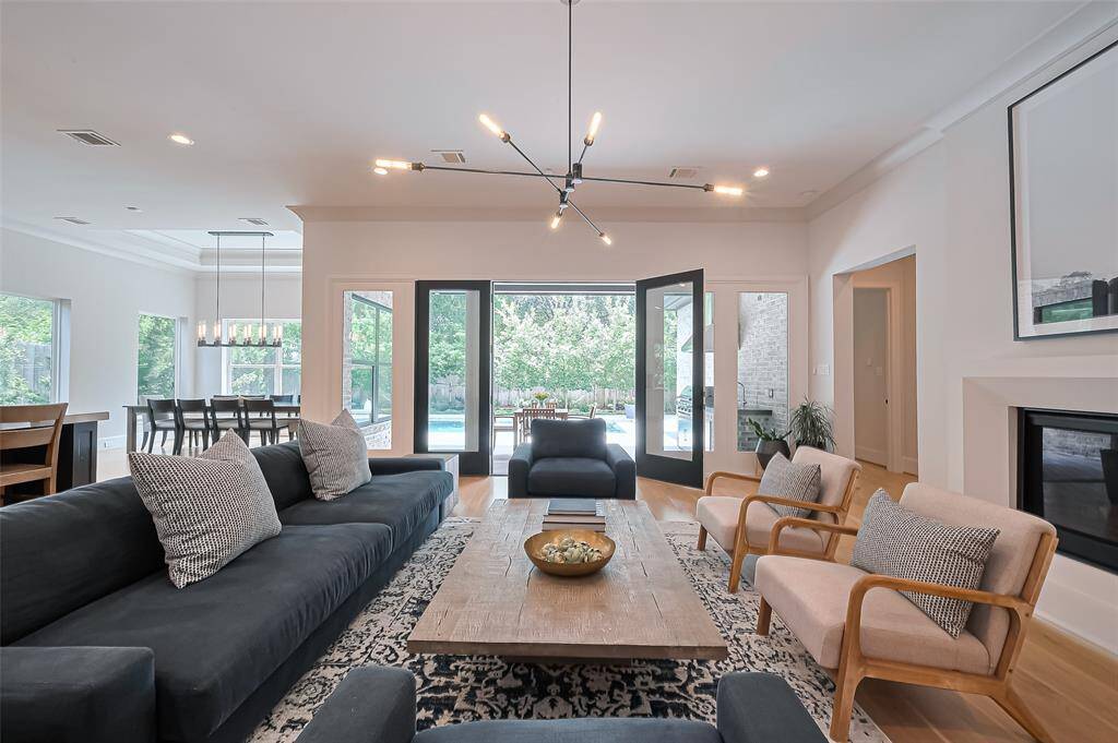 This view from the stunning living room captures the patio and outdoor space, showcasing a beautiful and modern pool/spa.