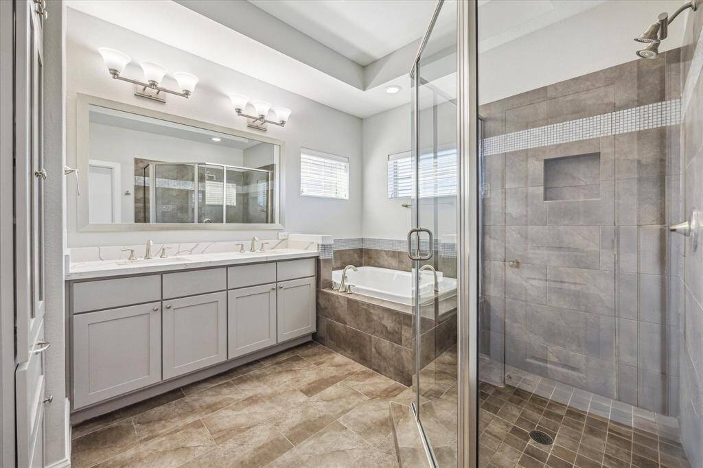 The owner's ensuite is a private retreat designed for ultimate comfort and luxury. It features a dual sink vanity, a relaxing soaking tub, an oversized walk-in shower, custom built-in storage, and a private water closet for added convenience.