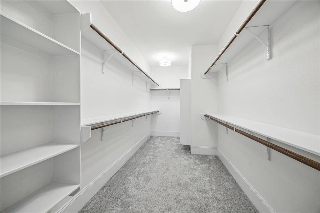 Shop until you drop! This deep walk-in closet has ample hanging bars for clothes and built-in shelving for shoes, bags, and more.