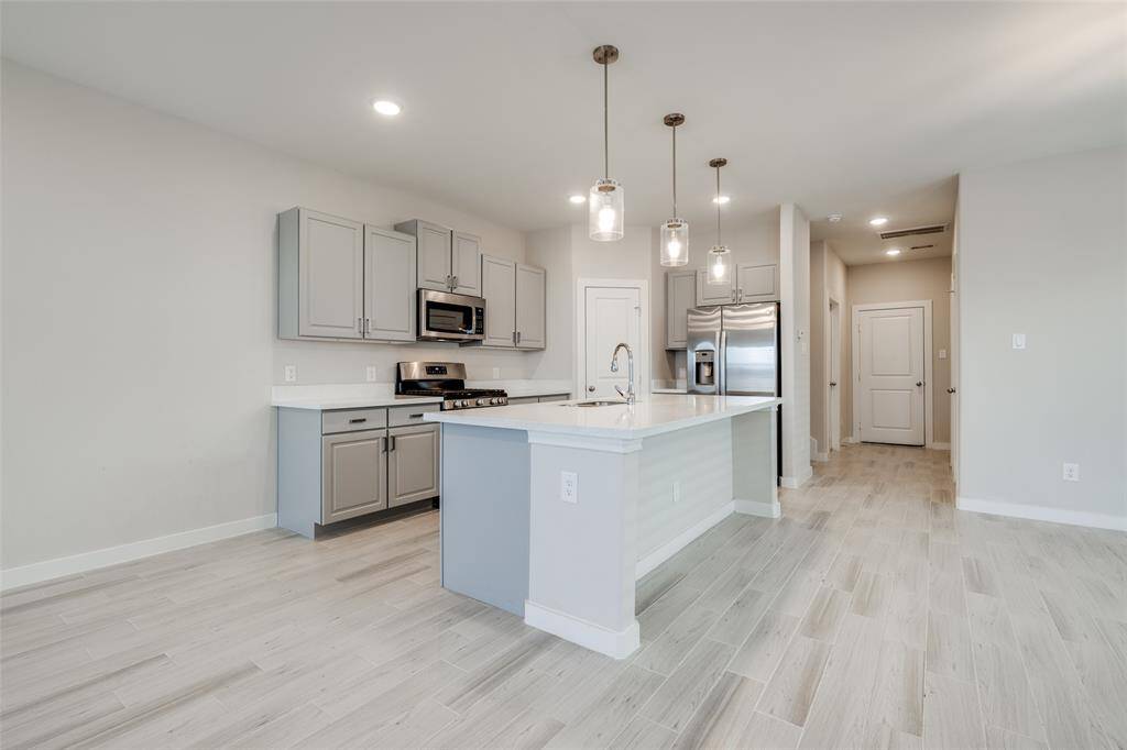 Sleek kitchen with oversized island—ideal for meal prep, serving, or gathering with friends and/or family.
