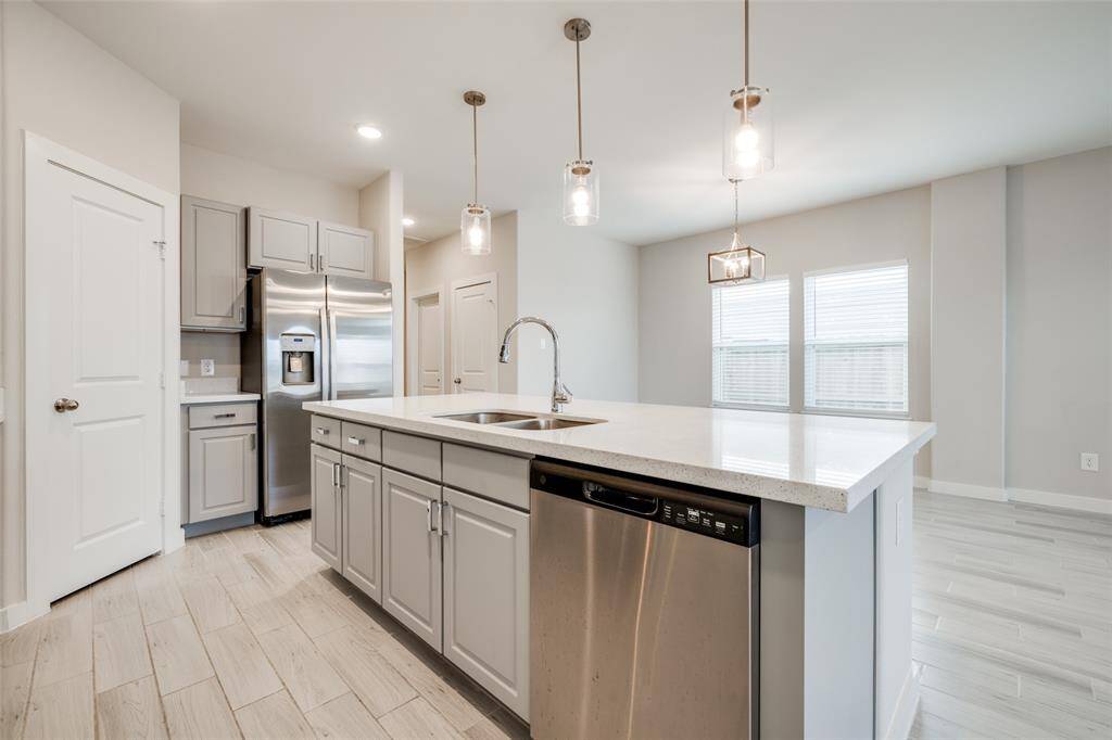 Ample storage, stainless steel appliances, and a sleek island with a dual sink—this kitchen is both stylish and functional.