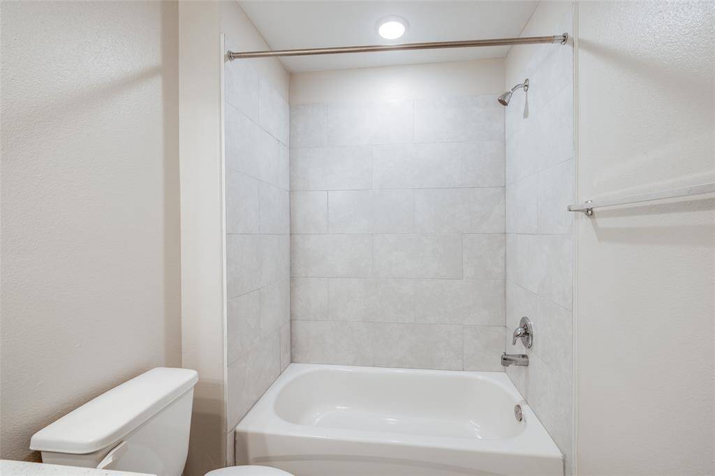 Full upstairs bath with tiled shower/tub combo—shared by secondary bedrooms.