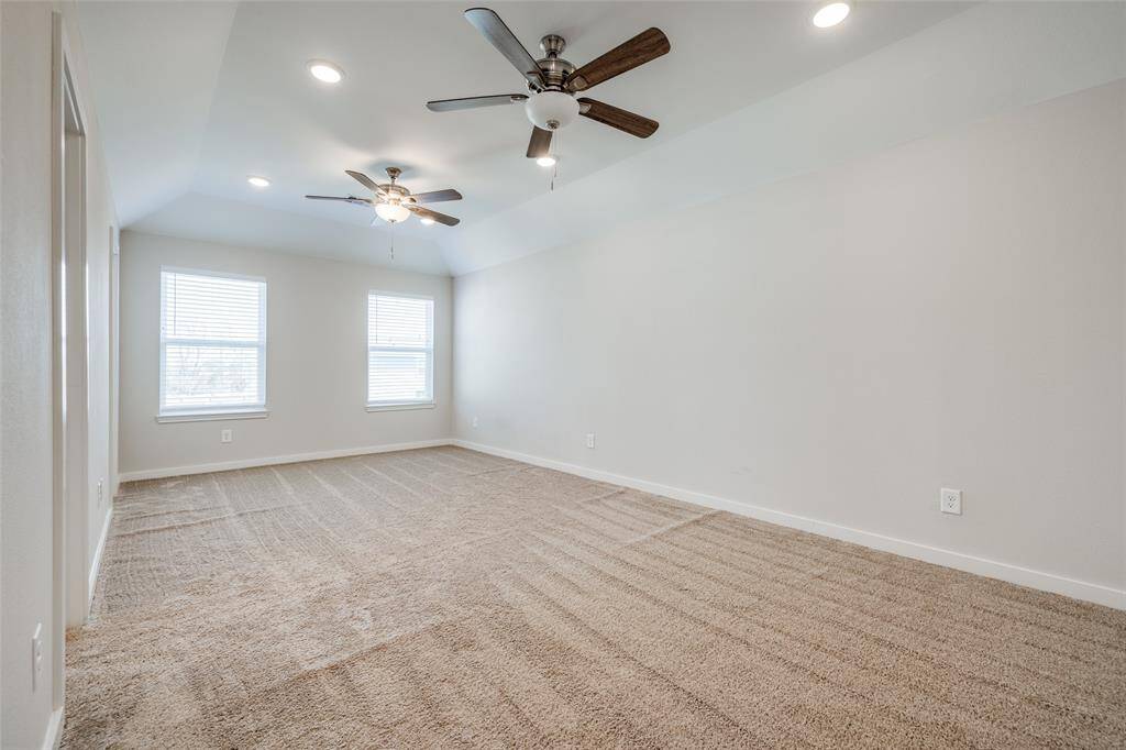 Roomy primary suite with vaulted ceilings and double ceiling fans.