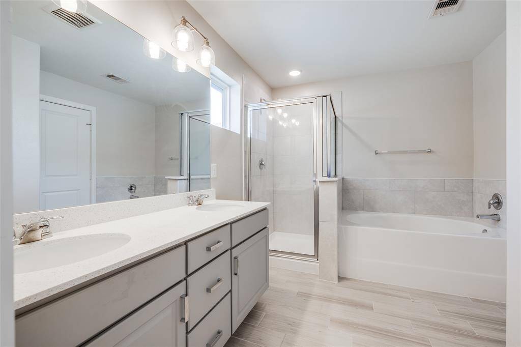 Bright and spacious primary bath with double sinks, separate shower, and soaking tub—plenty of room to unwind.