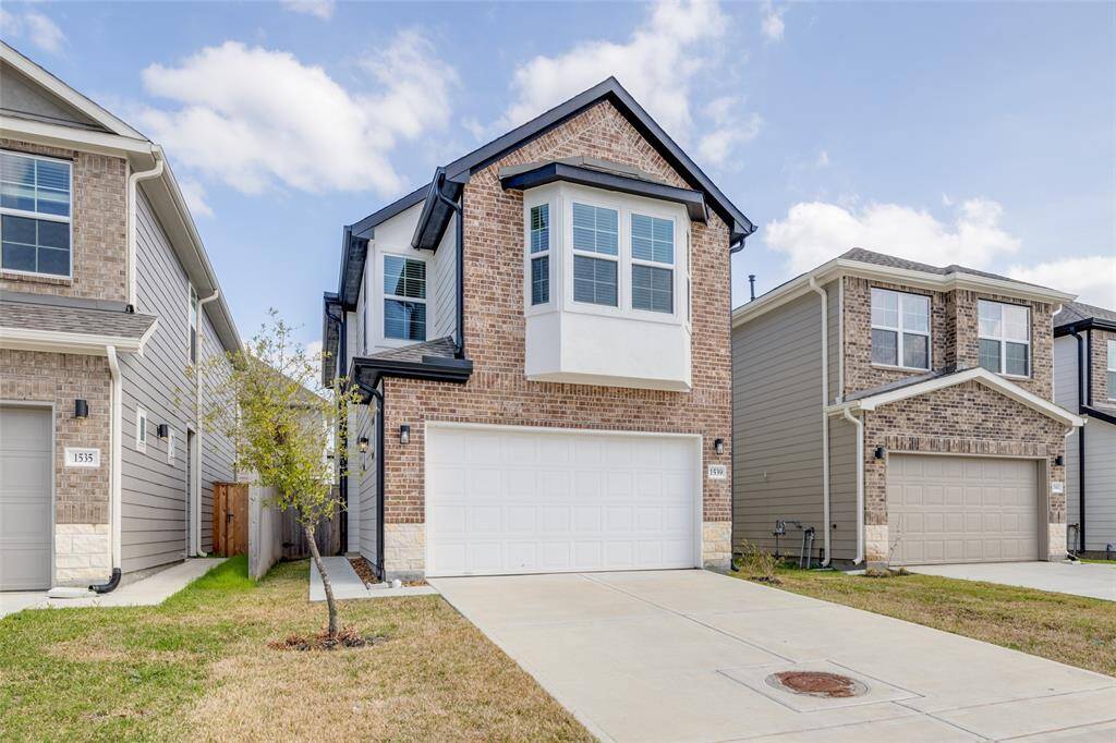 Clean two-story with brick front and two-car garage.