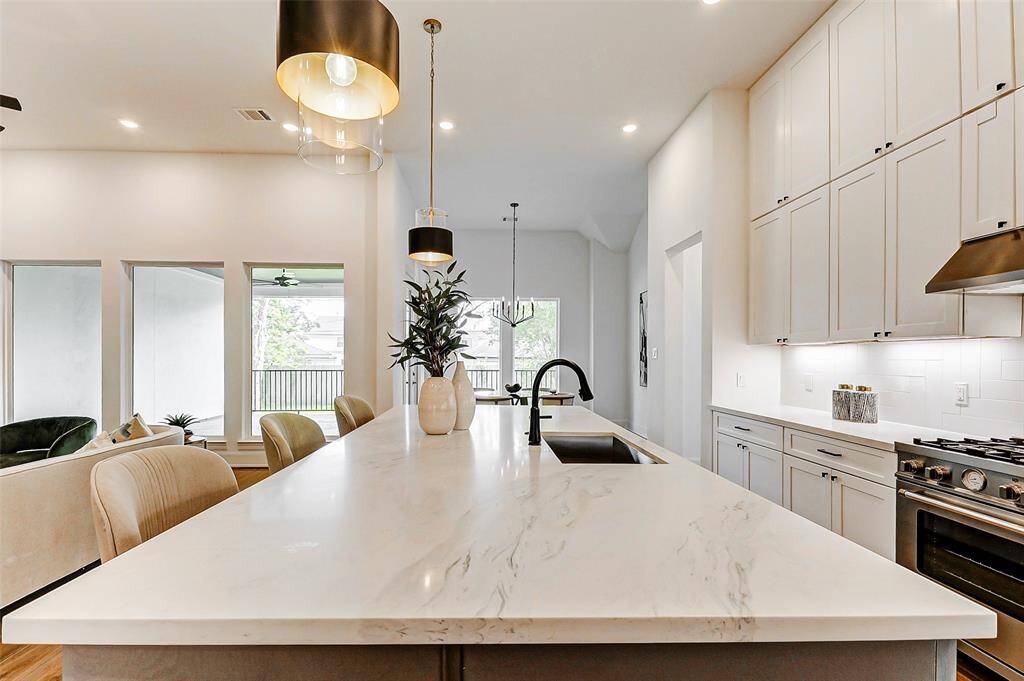 The oversized sink, paired with an elegant oil-rubbed bronze faucet, overlooks the family room, creating an inviting, open-concept flow perfect for both daily living and entertaining.