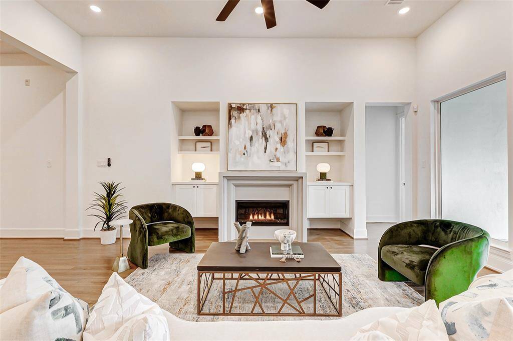Unwind by the cozy fireplace, an eye-catching focal point in the living room. Flanking the fireplace, floating cabinets and shelving add both style and functionality, creating a perfect space for relaxation and display.