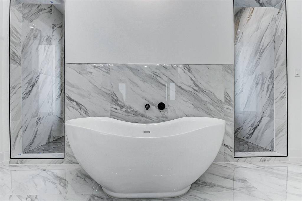 The freestanding tub is truly a work of art, adding a touch of elegance to the space. On either side, you'll find convenient access to the private walk-in shower, enhancing the seamless flow and luxury of the bathroom.