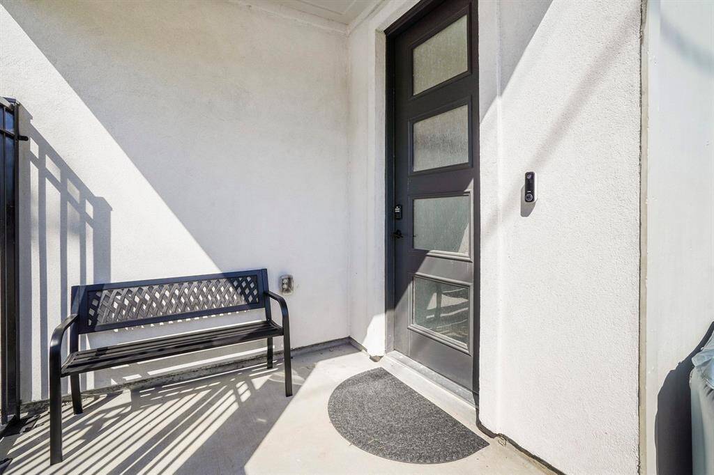 Sleek frosted glass door and inviting bench offers a nook to the entry of your new home.