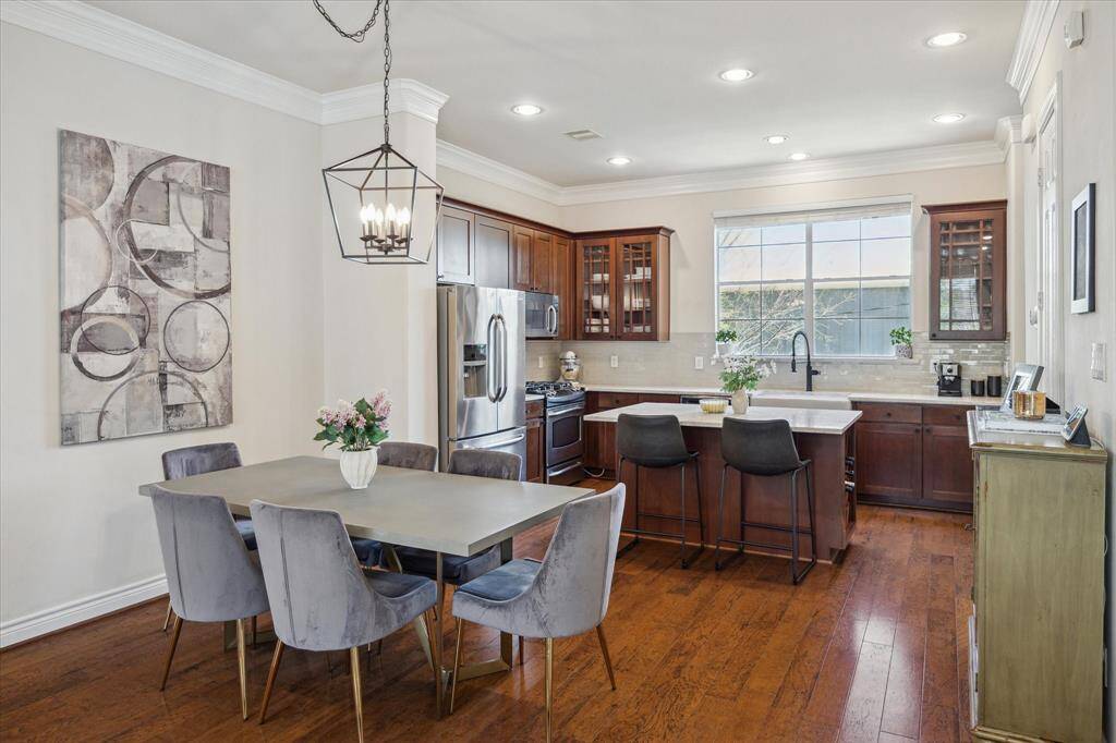 A modern chandelier above the dining room table adds a touch of elegance and style.