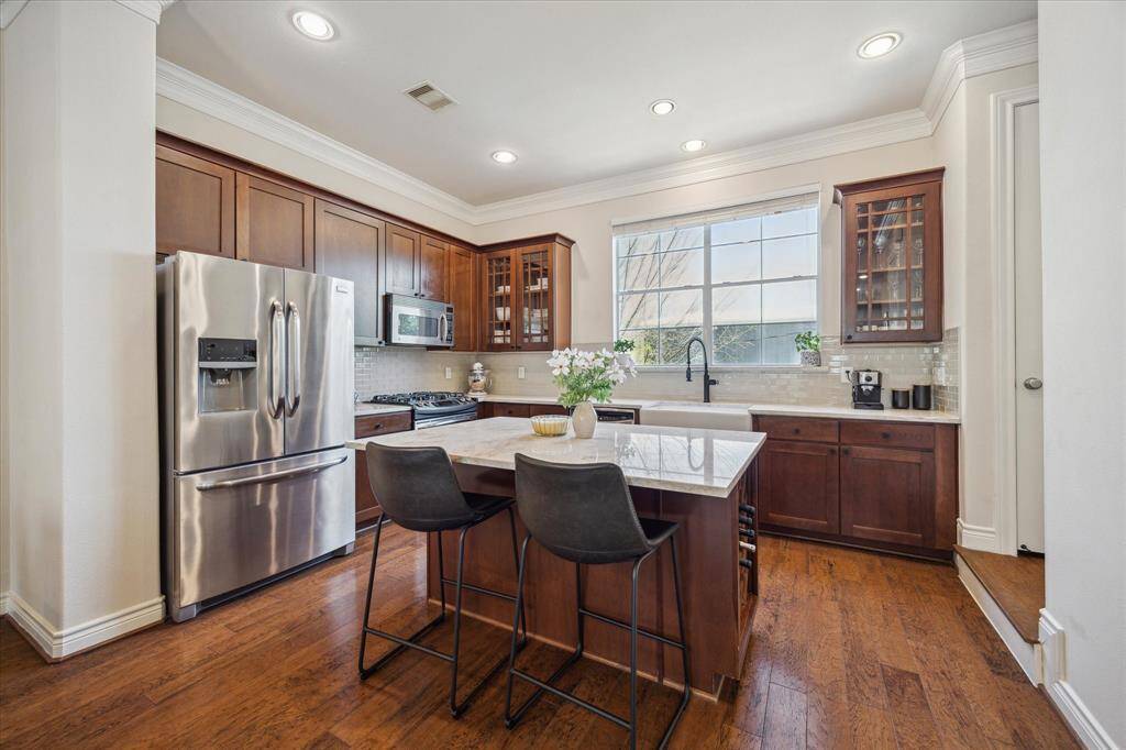 The kitchen features a spacious island with seating for two and plenty of storage. Just to the right, a door leads to the pantry for easy access.