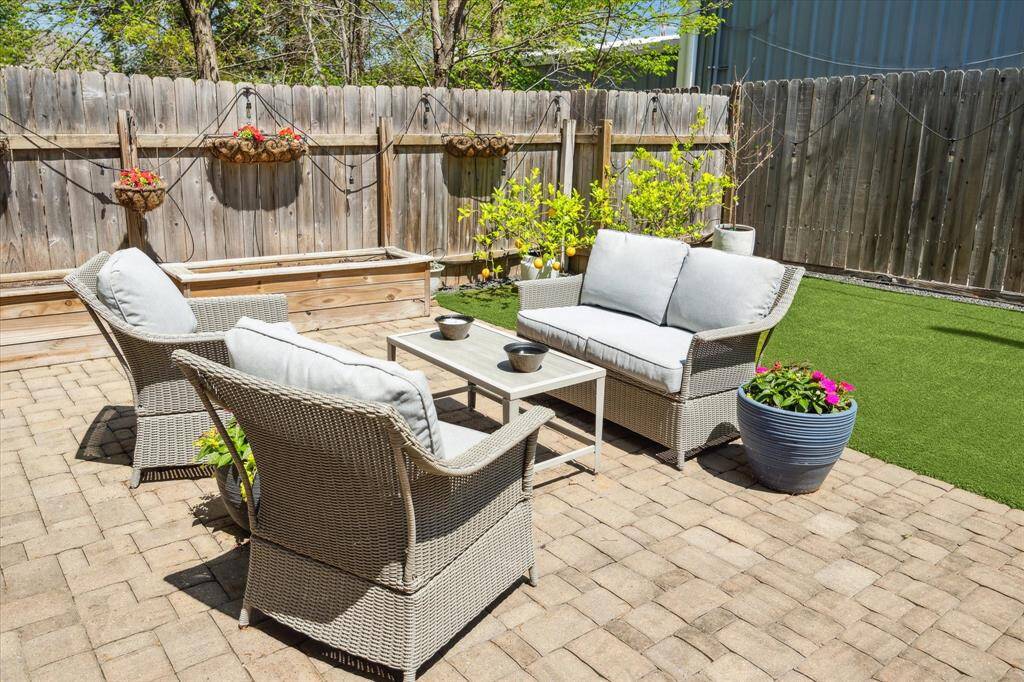 A backyard built for fun—turf for pets, a paver patio for lounging, and garden boxes ready for your green thumb.