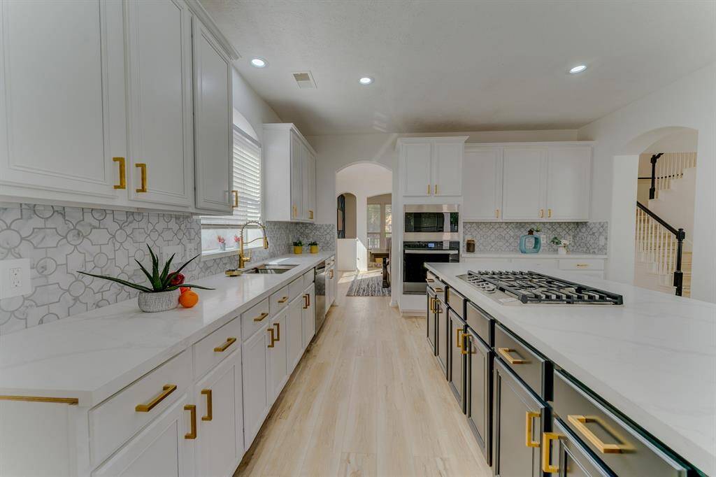 Beautiful fully remodeled & updated kitchen with quartz countertops and gold hardware and fixtures