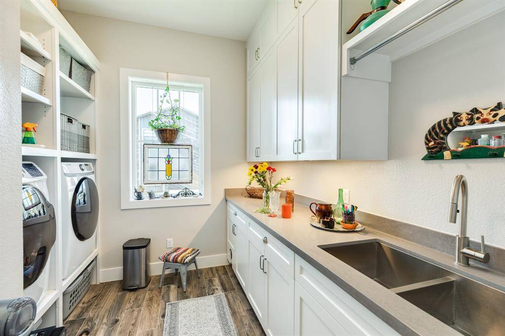 Very spacious laundry room has a full size washer and dryer dual sinks lots of cabinet and storage space