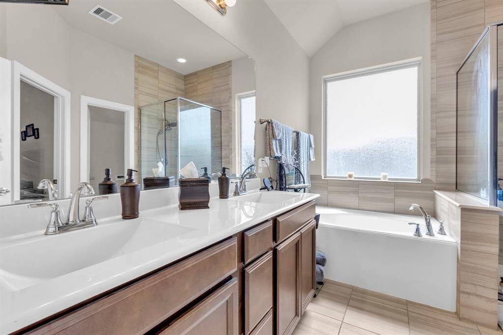 This bathroom has both a shower and tub as well as dual sinks.