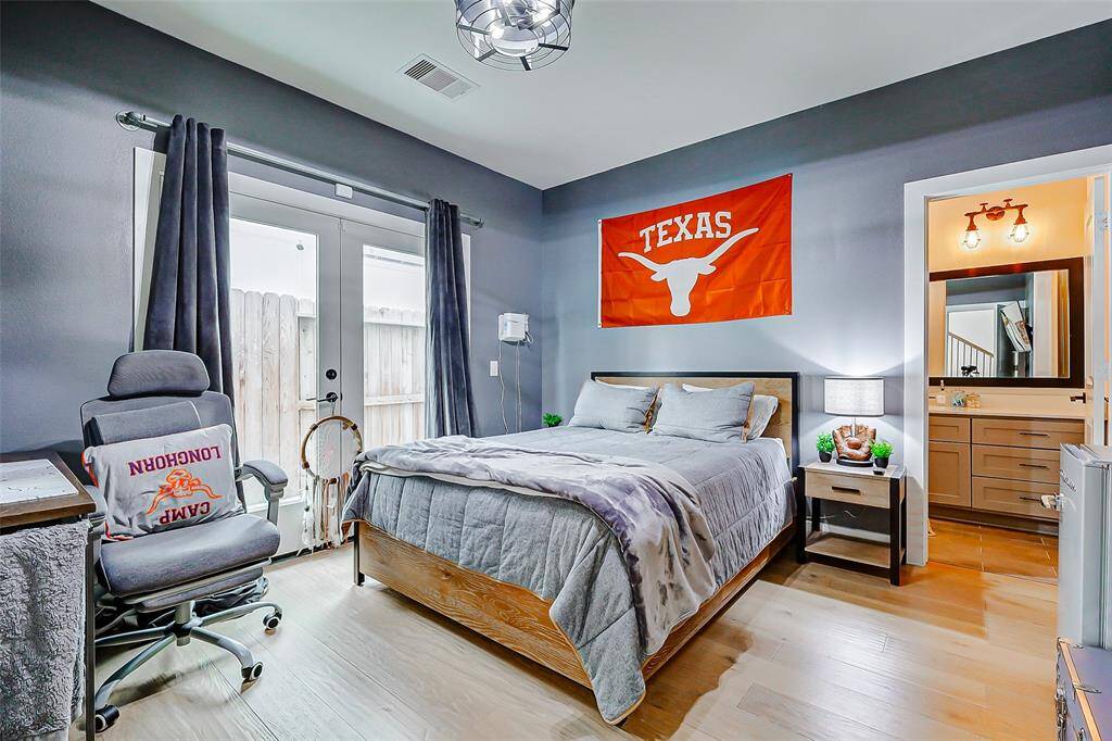 First floor secondary bedroom with engineered wood flooring and access to the side yard.