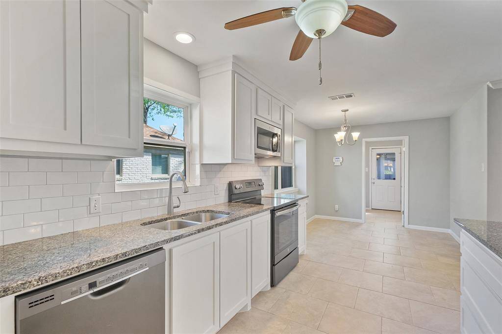 The kitchen is outfitted with GE appliances – including a smudge-proof slate-like dishwasher, electric range, oven, and built-in microwave – adding both functionality and elegance. An LG fridge/freezer with water and ice dispenser completes the perfect kitchen setup.