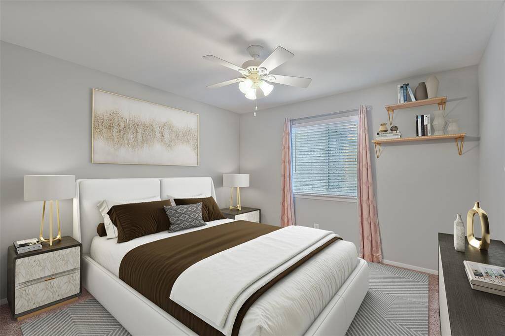Bright and inviting secondary bedroom #2 with freshly steamed plush carpet.  This room features a spacious closet, a window with blinds and drapes, and included display/book shelves. A ceiling fan/light fixture adds comfort and style to the space. Note: this photo has been virtually staged.
