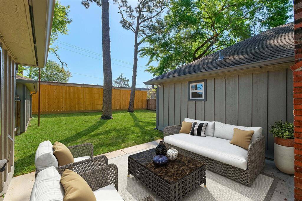 This backyard is an entertainer's dream! Spacious backyard featuring a large patio, perfect for al fresco dining, complete with an outdoor TV (included) and added electrical outlets for convenience. Newly installed back privacy fence (2024). Note: this photo has been virtually staged.