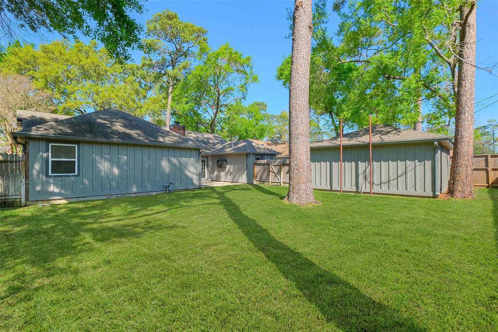 Another view of this fenced-in, pool-sized backyard offers plenty of room for kids and pets to play, surrounded by mature trees. Additional upgrades include gutters with leaf guards (2018).