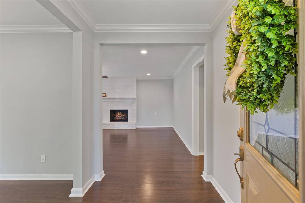 Step into this welcoming entrance with sleek engineered hardwood floors, decorative light fixture and crown molding. You will find the entire home has been repainted in March 2025. This lovely residence is outfitted with great storage with a mudroom and 3 large hall closets.