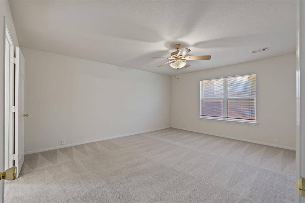 The primary bedroom on the first floor with a view of the pool from the windows.