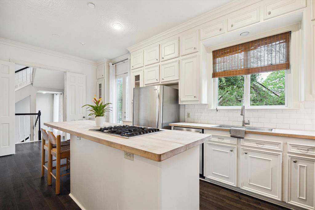 A casement window above the oversized stainless steel sink offers a view of greenery and fresh air when opened. With lots of counter space and large pantry, the kitchen is inspirational for the creative chef.