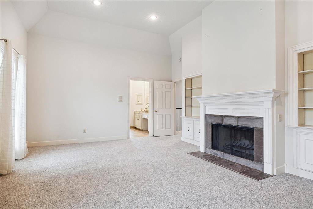 Wonderful primary suite with high coffered ceiling, wood burning fireplace, built-in shelving & cabinets, and large windows creates a bright and inviting atmosphere. The room is large enough to encompass a sitting area as well.